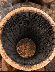 Interior of a number 4 alligator char oak barrel, deeply cracked charcoal surface